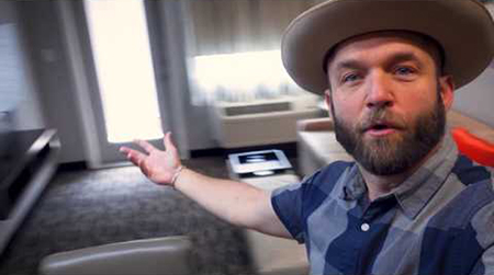 Man in hat vlogging in hotel room