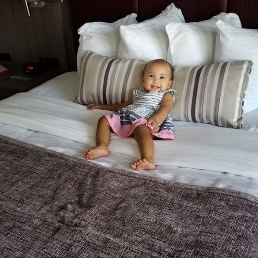 Baby laying on Best Western hotel bed