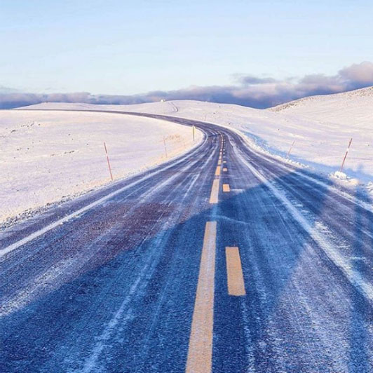 Road in between snow covered landscape