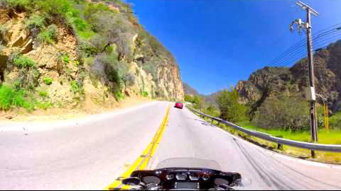 Driving view of a motorcycle going down Mailbu road