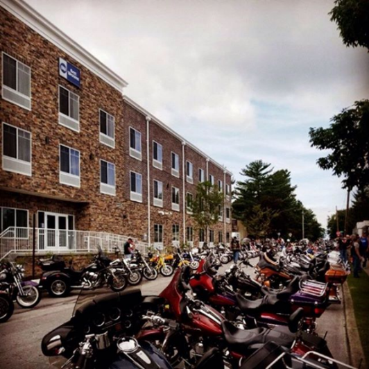 Group of motorcycles parked outside of brick building