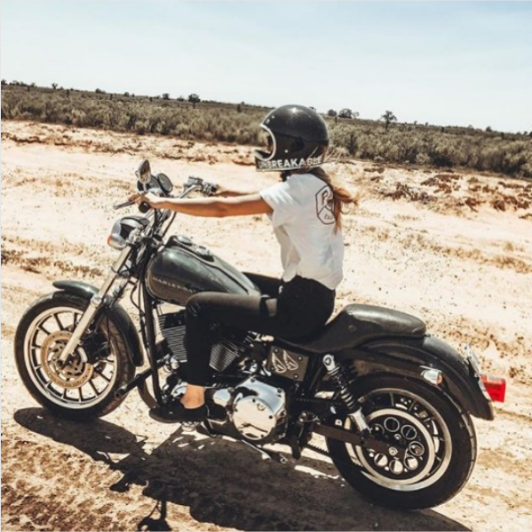 Woman riding motorcycle on dirt road
