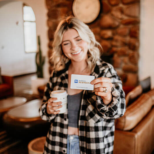 Blonde in black and white flannel holding a card