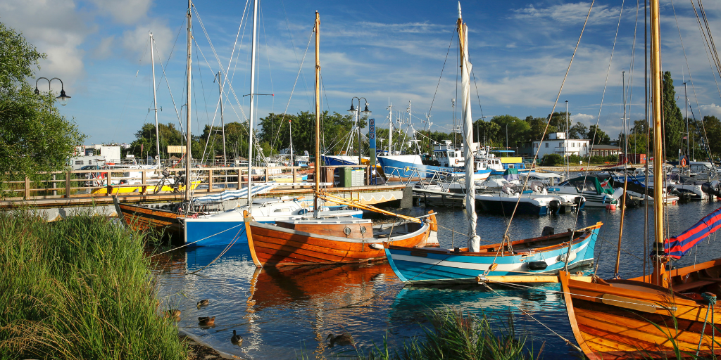 colorful sailboats sit in a harbor