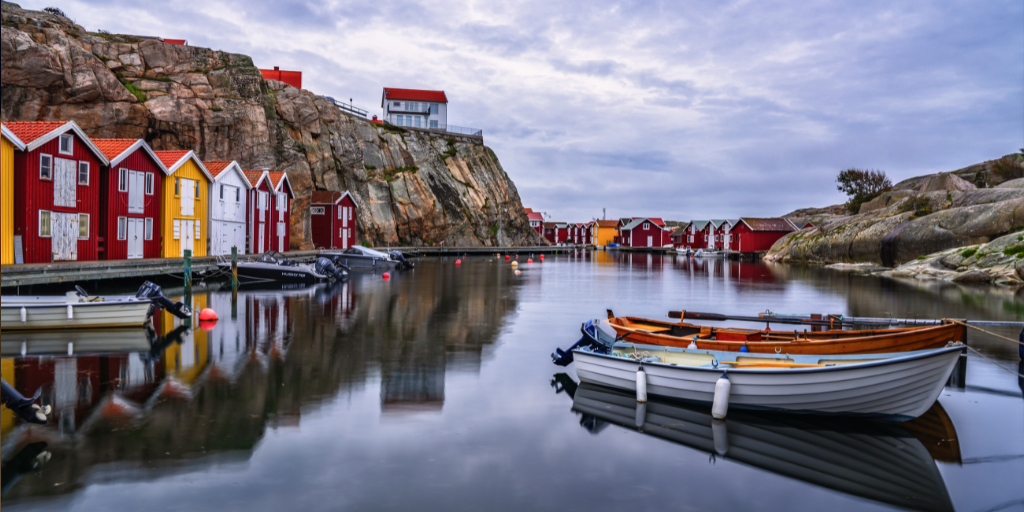 Gotland Sweden with a boat sitting in water surrounded by beautiful bright buildings and a rocky landscape
